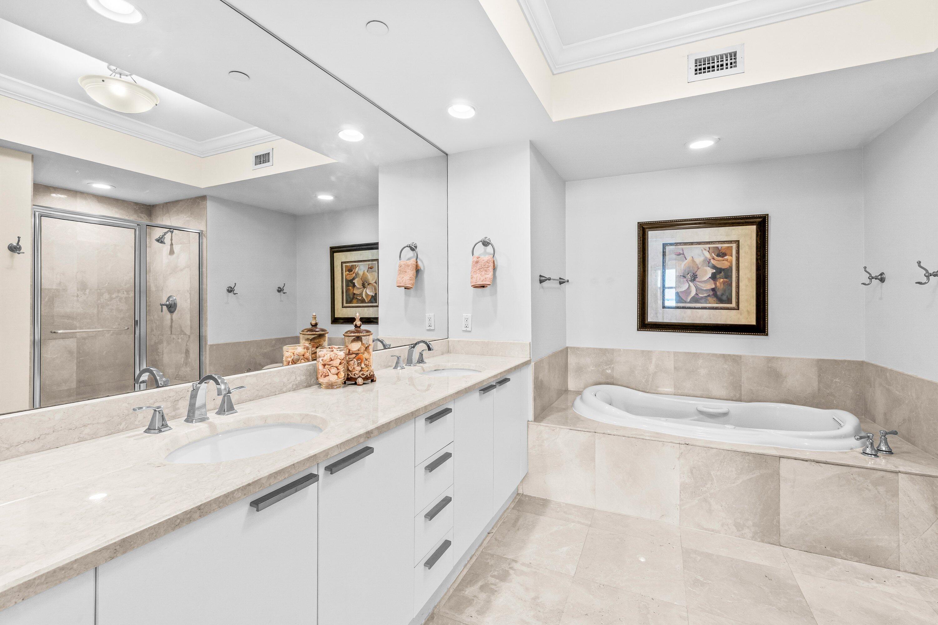 2650 Lake Shore Drive, Unit 703 Riviera Beach, FL 33404 - Photo 18 of 56 a spacious bathroom with a double vanity sink tub and mirror