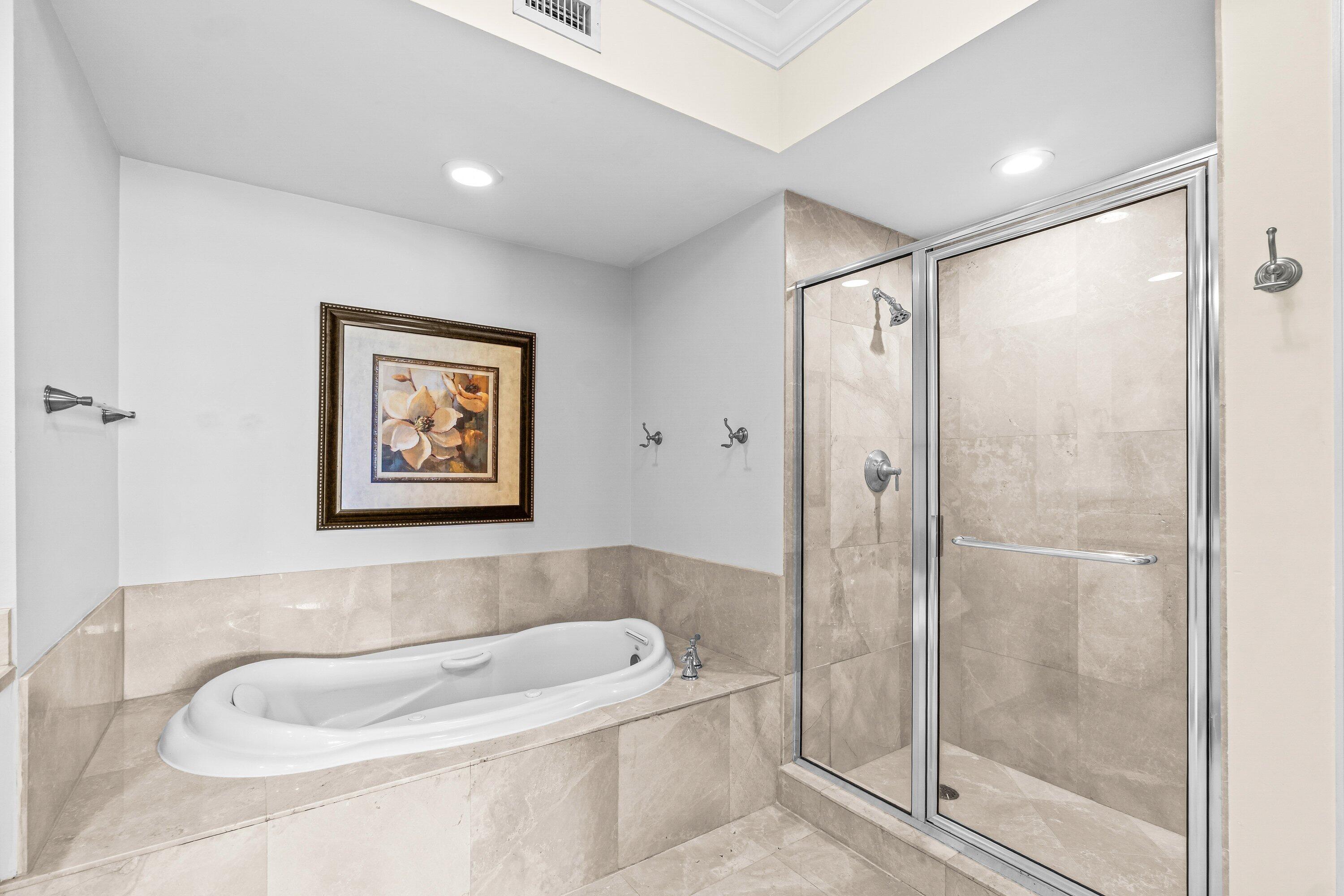 2650 Lake Shore Drive, Unit 703 Riviera Beach, FL 33404 - Photo 19 of 56 a bathroom with a tub and shower