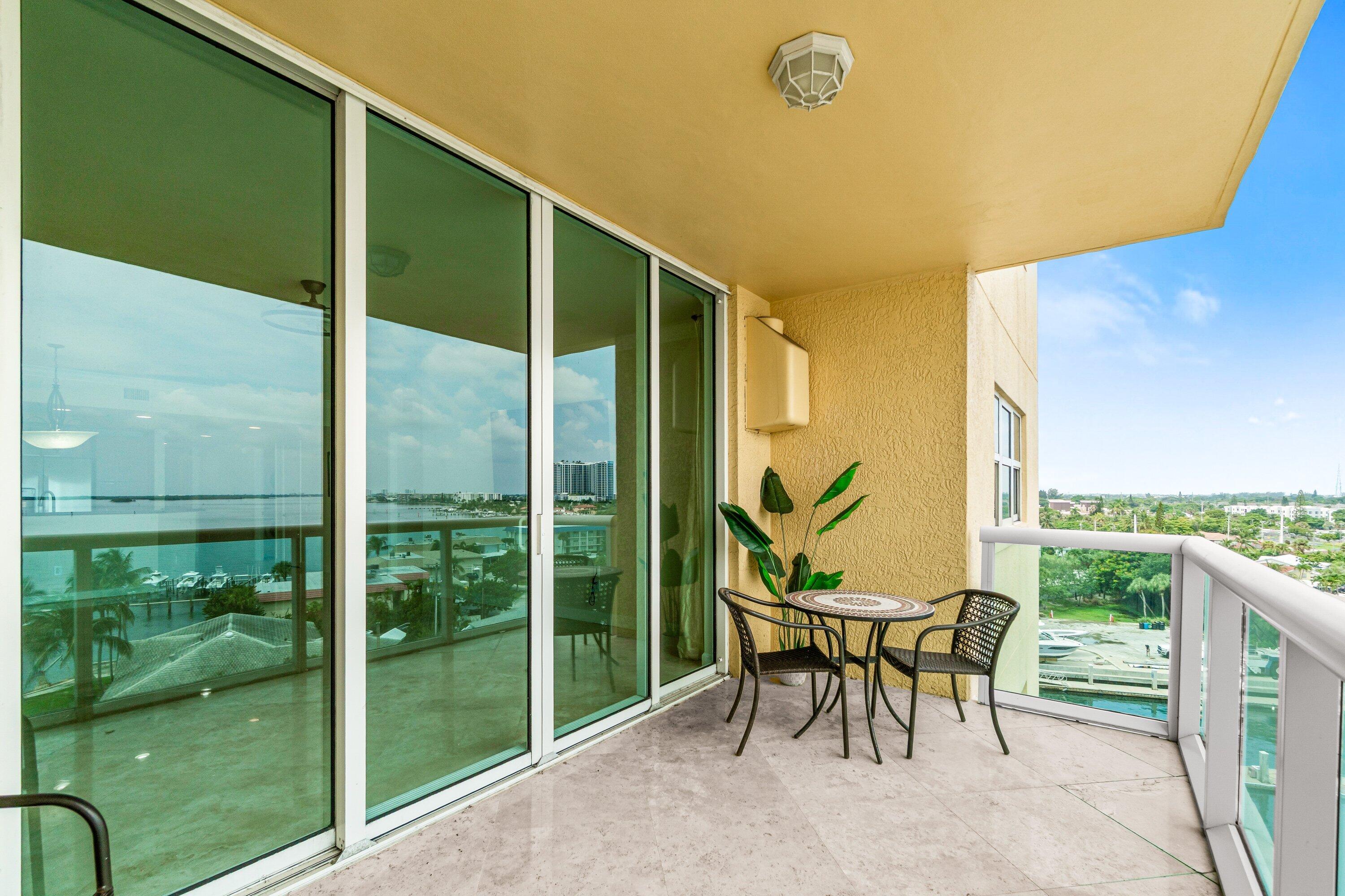 2650 Lake Shore Drive, Unit 703 Riviera Beach, FL 33404 - Photo 29 of 56 a porch with a table and chairs