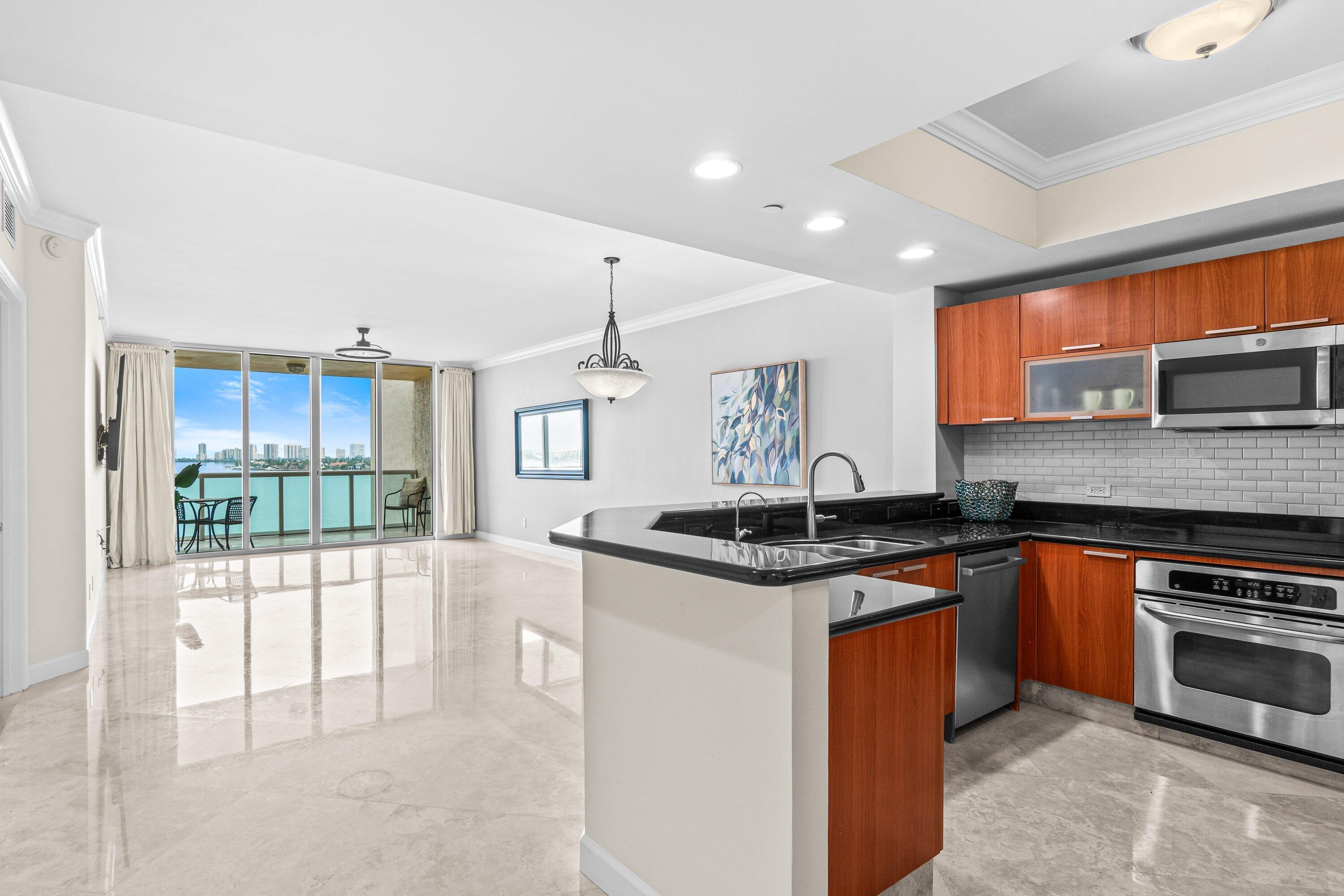2650 Lake Shore Drive, Unit 703 Riviera Beach, FL 33404 - Photo 3 of 56 a kitchen with stainless steel appliances granite countertop a stove top oven