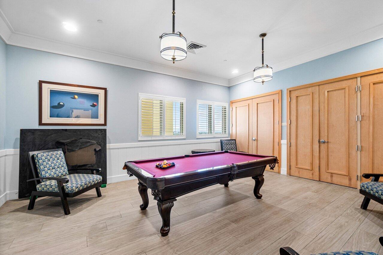 2650 Lake Shore Drive, Unit 703 Riviera Beach, FL 33404 - Photo 46 of 56 a pool table with a couch and a chandelier