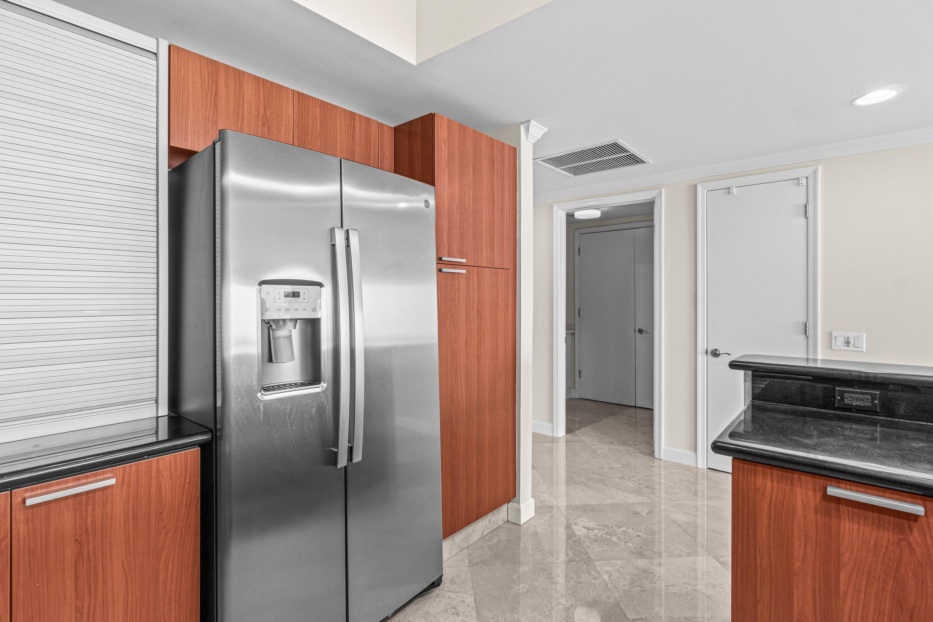 2650 Lake Shore Drive, Unit 703 Riviera Beach, FL 33404 - Photo 8 of 56 a kitchen with stainless steel appliances granite countertop a refrigerator and a stove