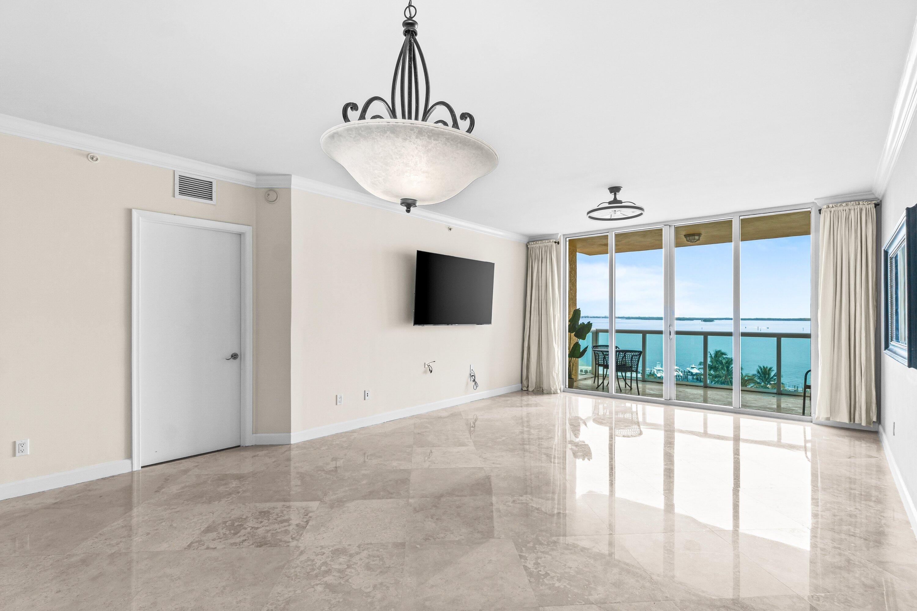 2650 Lake Shore Drive, Unit 703 Riviera Beach, FL 33404 - Photo 9 of 56 a living room with furniture and a flat screen tv