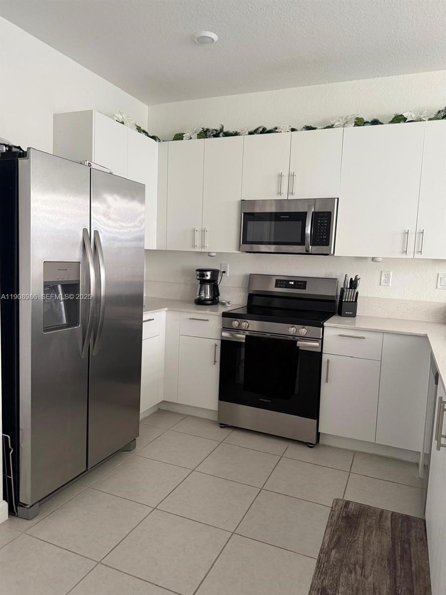 2894 Southeast 26th Terrace, Unit 1 Homestead, FL 33035 - Photo 2 of 11 a kitchen with a refrigerator stove and microwave