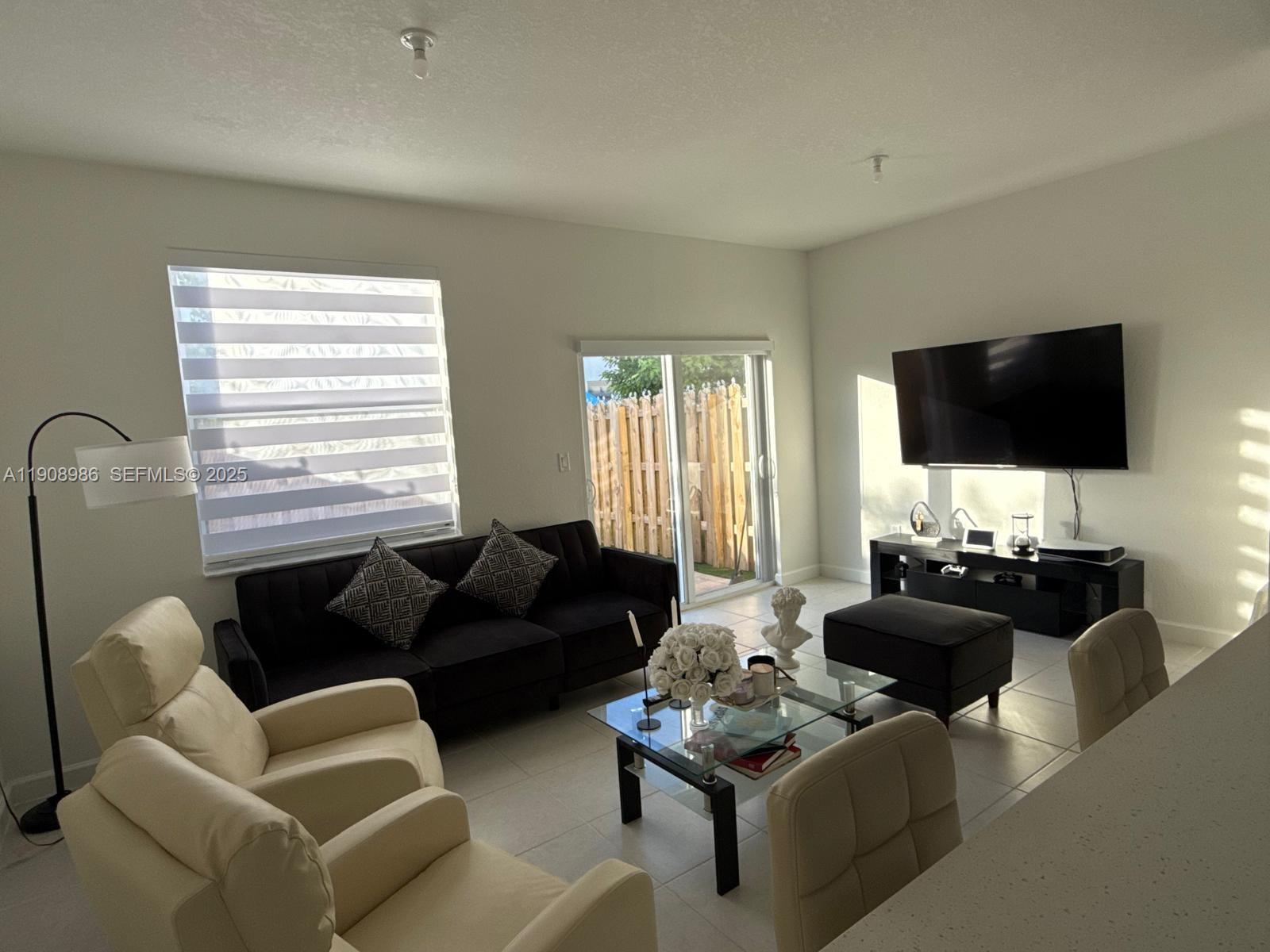 2894 Southeast 26th Terrace, Unit 1 Homestead, FL 33035 - Photo 5 of 11 a living room with furniture and a flat screen tv