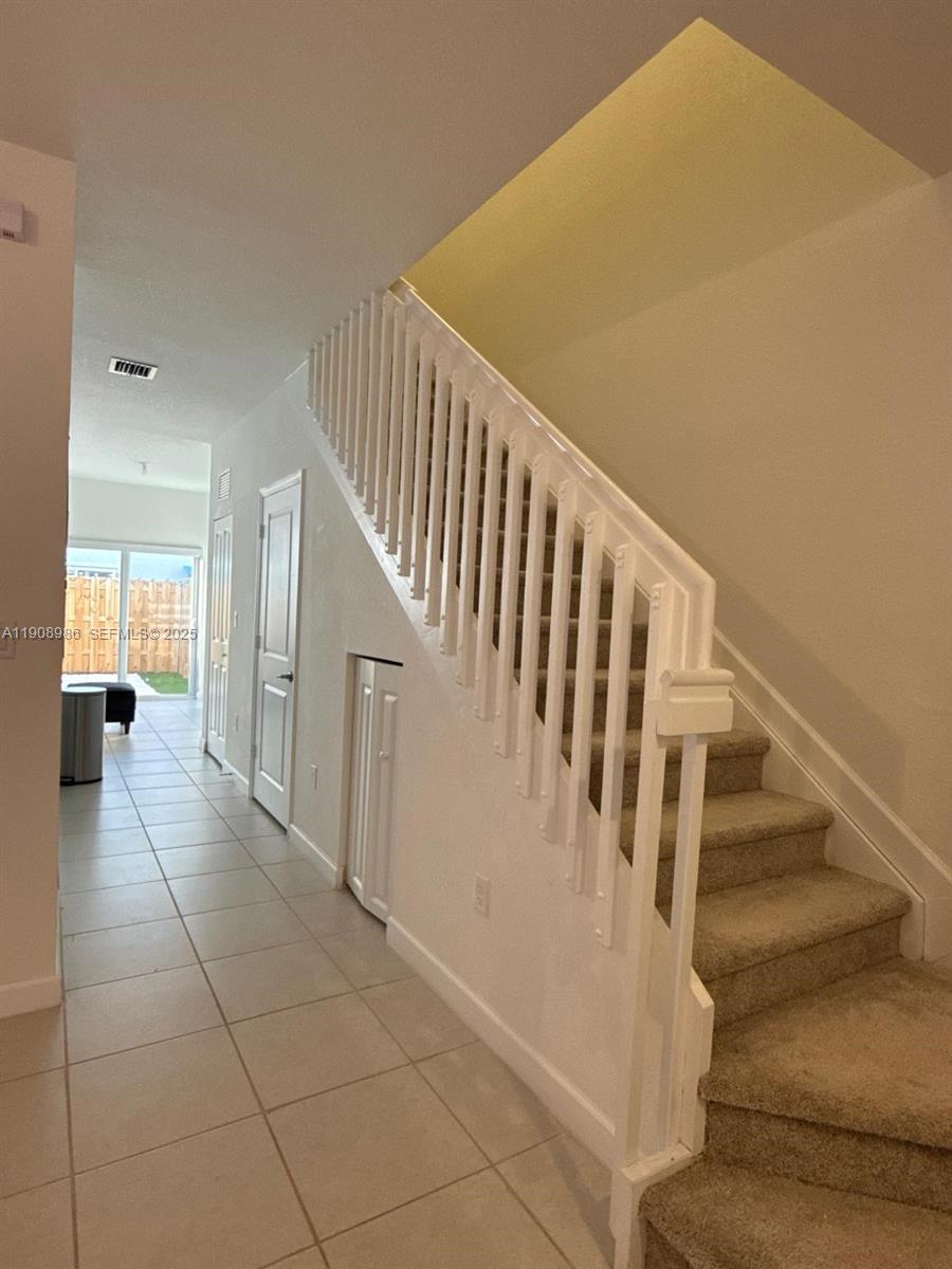 2894 Southeast 26th Terrace, Unit 1 Homestead, FL 33035 - Photo 8 of 11 a view of staircase with lots of frames and white walls
