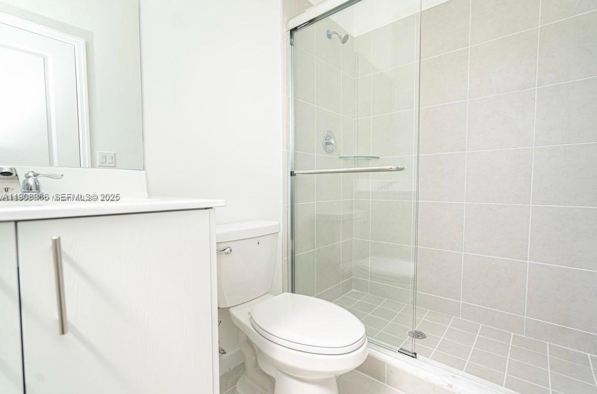 2894 Southeast 26th Terrace, Unit 1 Homestead, FL 33035 - Photo 9 of 11 a bathroom with a granite countertop sink toilet and shower