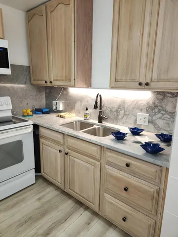 a kitchen with sink and view of living room