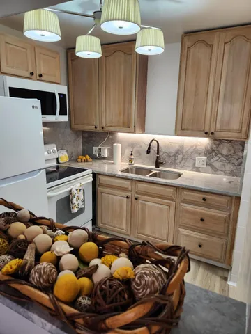 a kitchen with sink stove and cabinets