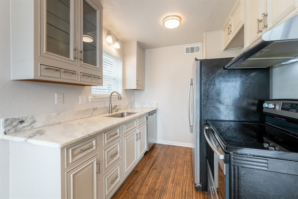 4610 Chaha Road, Unit 106 Garland, TX 75043 - Photo 10 of 25 a kitchen with a sink stove and cabinets