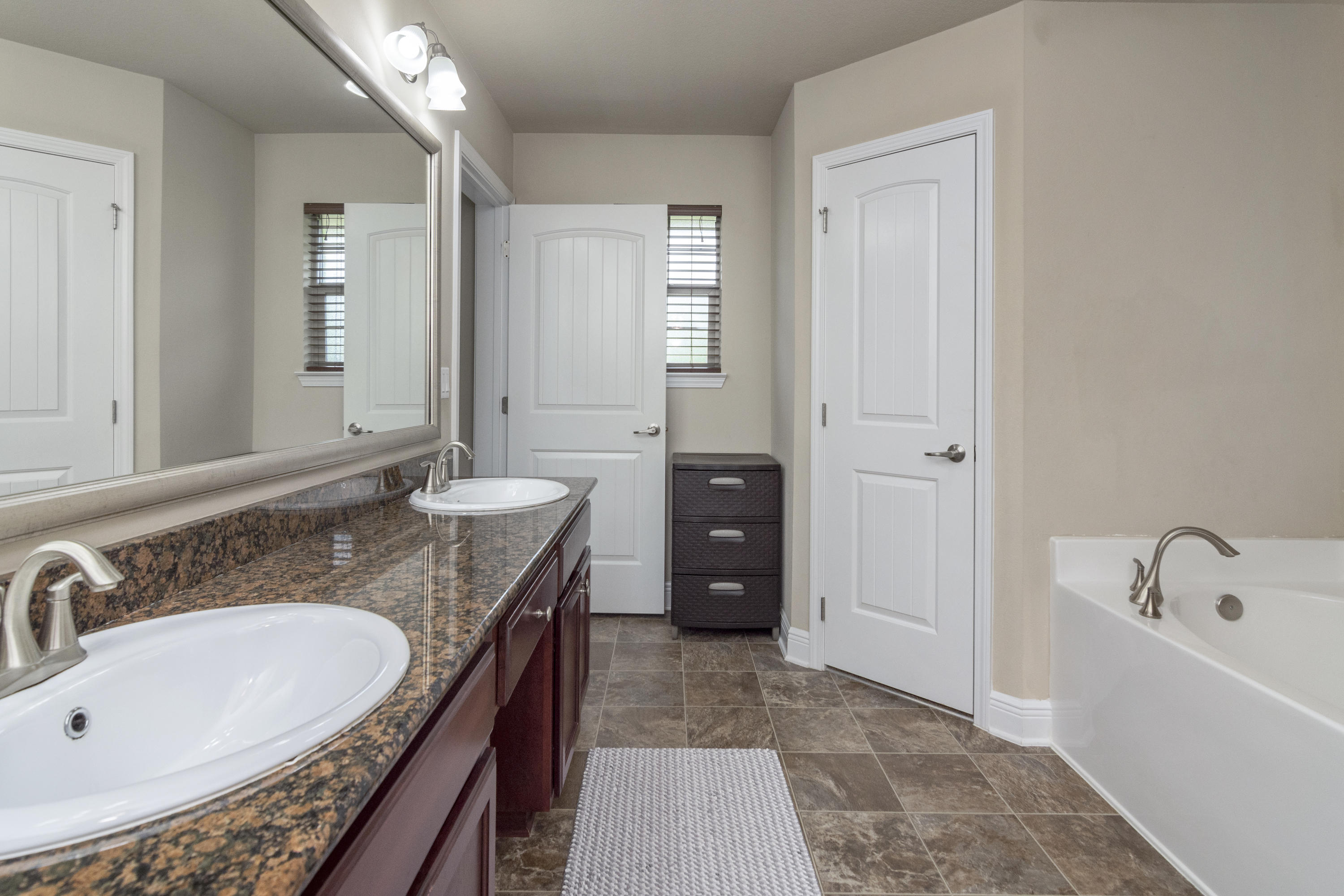 306 Gauntlet Drive Crestview, FL 32539 - Photo 20 of 32 a bathroom with a granite countertop tub sink and mirror