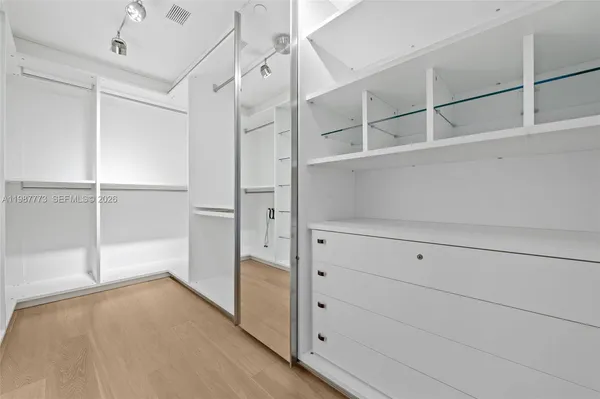 a bedroom with a bed a dresser and next to a window