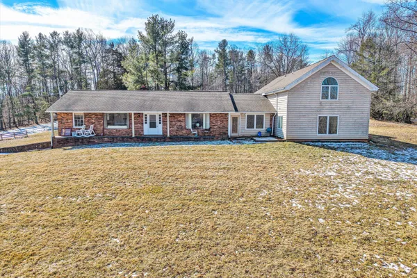 a view of a house with a yard covered in snow