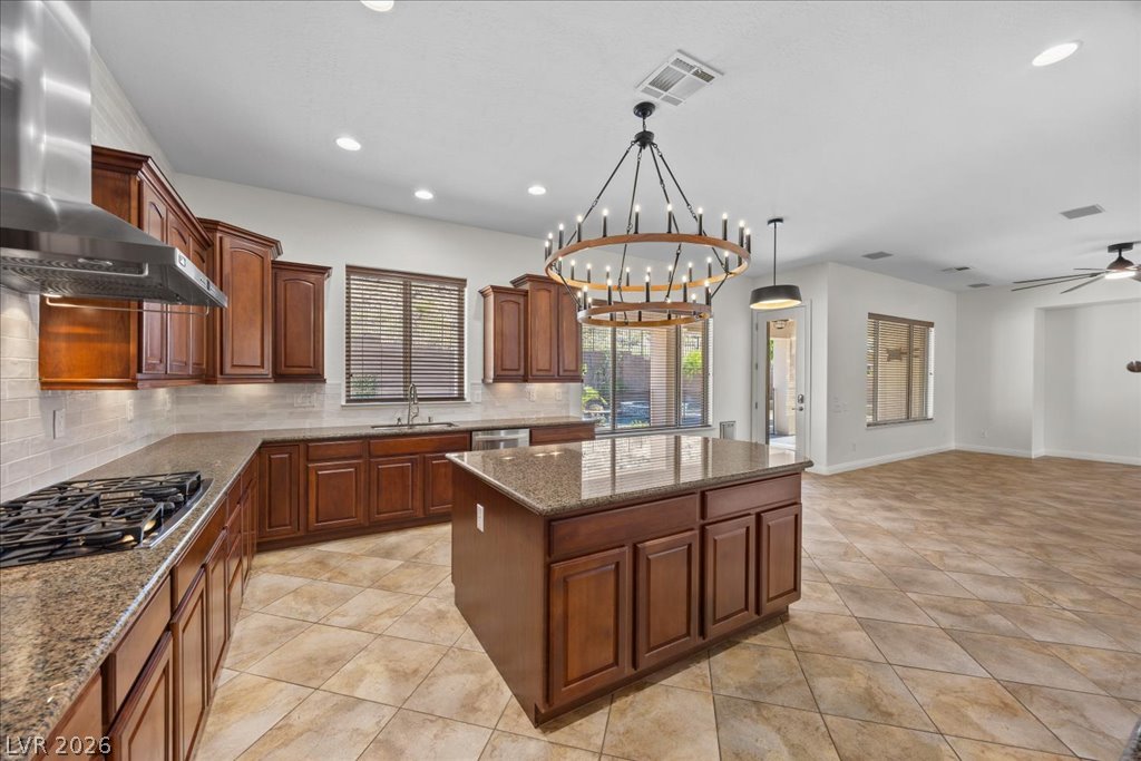2125 De Rouge Avenue Henderson, NV 89044 - Photo 43 of 96 A grand, open-concept kitchen with a large central island and rich cabinetry flows seamlessly into the living space.