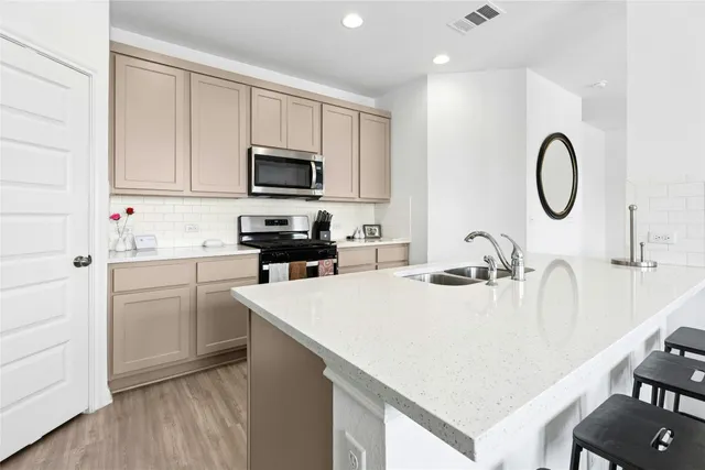 a kitchen with kitchen island a sink a stove and a microwave oven with wooden floor