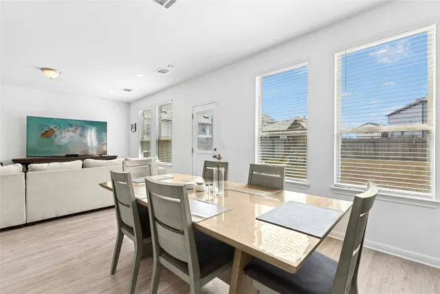 a dining room with furniture window and wooden floor