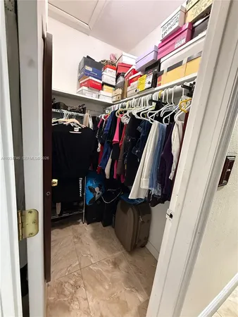 a view of walk in closet with clothes and shoes
