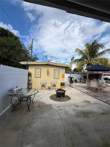 a view of a patio with table and chairs and potted plants