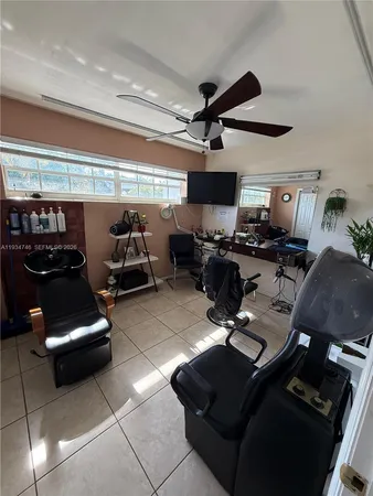 a living room with furniture a flat screen tv and gym equipment