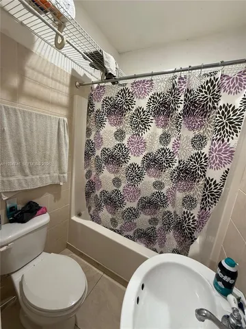 a bathroom with a toilet and a shower curtain