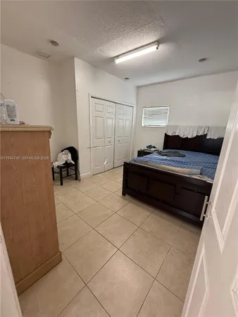 a bedroom with a bed and a lamp on the dresser