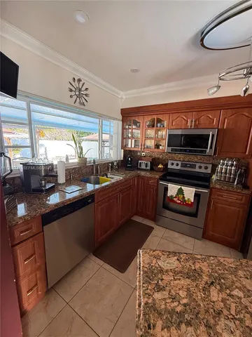 a kitchen with stainless steel appliances kitchen island granite countertop a stove a sink and a microwave
