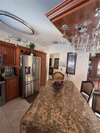 a kitchen with stainless steel appliances kitchen island granite countertop a refrigerator and stove