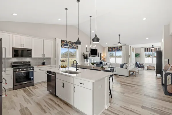 a kitchen with a sink stove and wooden floor