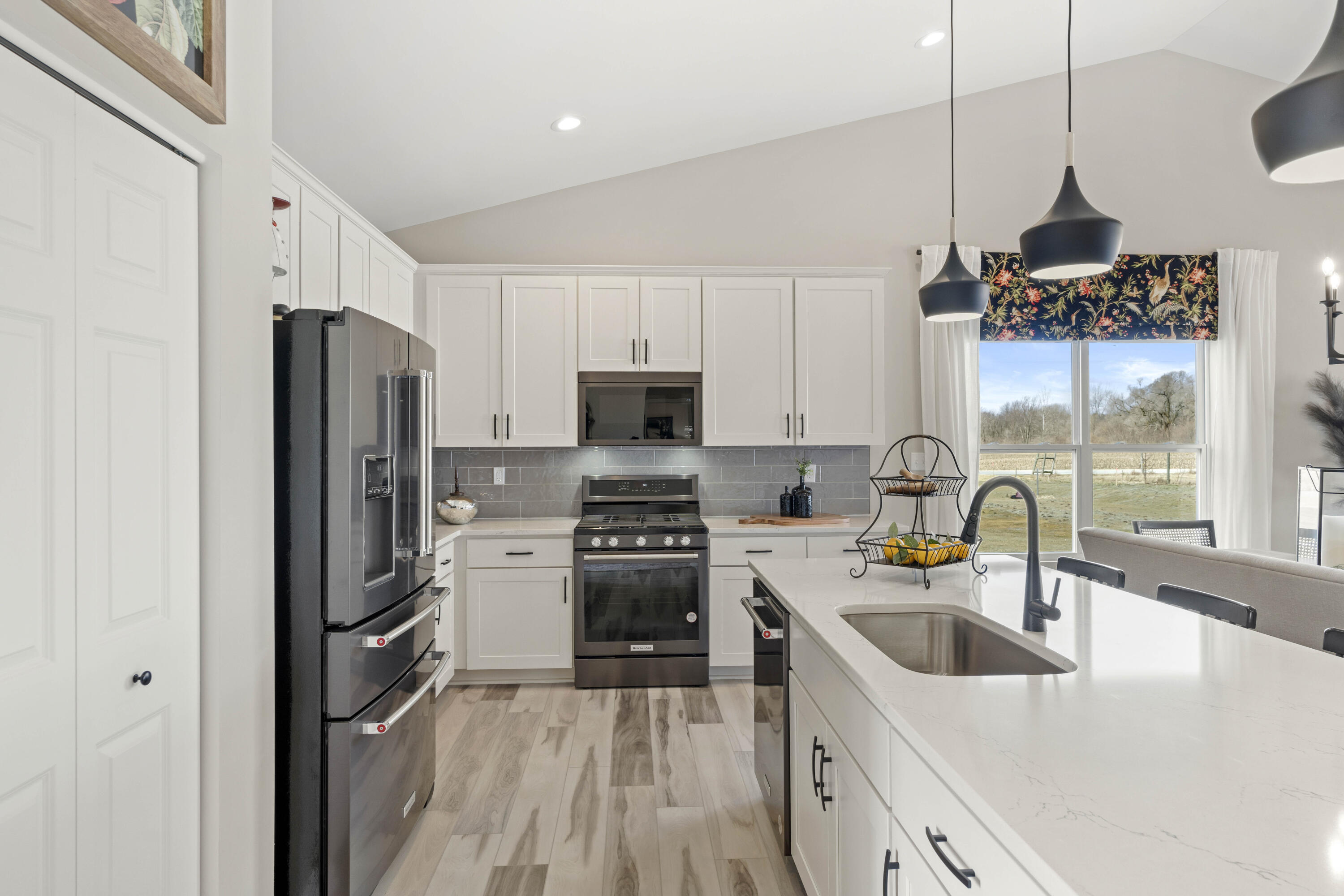 10362 Knox Street Crown Point, IN 46307 - Photo 4 of 14 a kitchen with stainless steel appliances granite countertop a refrigerator a sink dishwasher a stove and a dining table with wooden floor