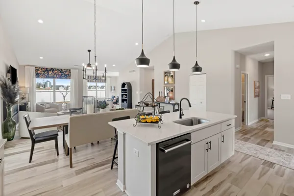 a kitchen with stainless steel appliances granite countertop a sink a stove and chairs