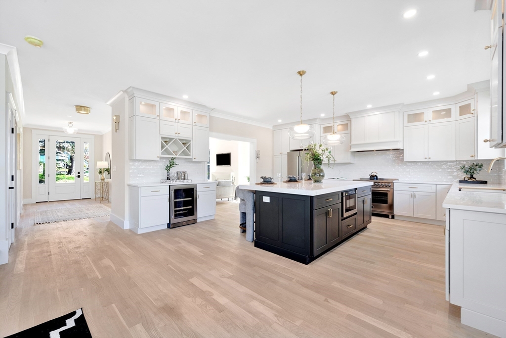354 Ridge Street Arlington, MA 02474 - Photo 18 of 42 a large kitchen with stainless steel appliances kitchen island granite countertop a stove a refrigerator a sink dishwasher and white cabinets with wooden floor