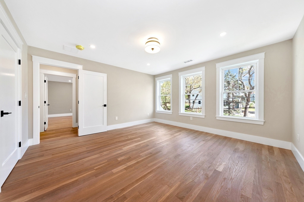 354 Ridge Street Arlington, MA 02474 - Photo 22 of 42 a view of an empty room with wooden floor and a window