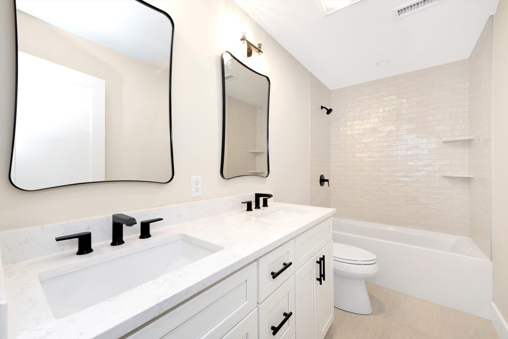 354 Ridge Street Arlington, MA 02474 - Photo 28 of 42 a bathroom with a double vanity sink mirror double vanity and bathtub
