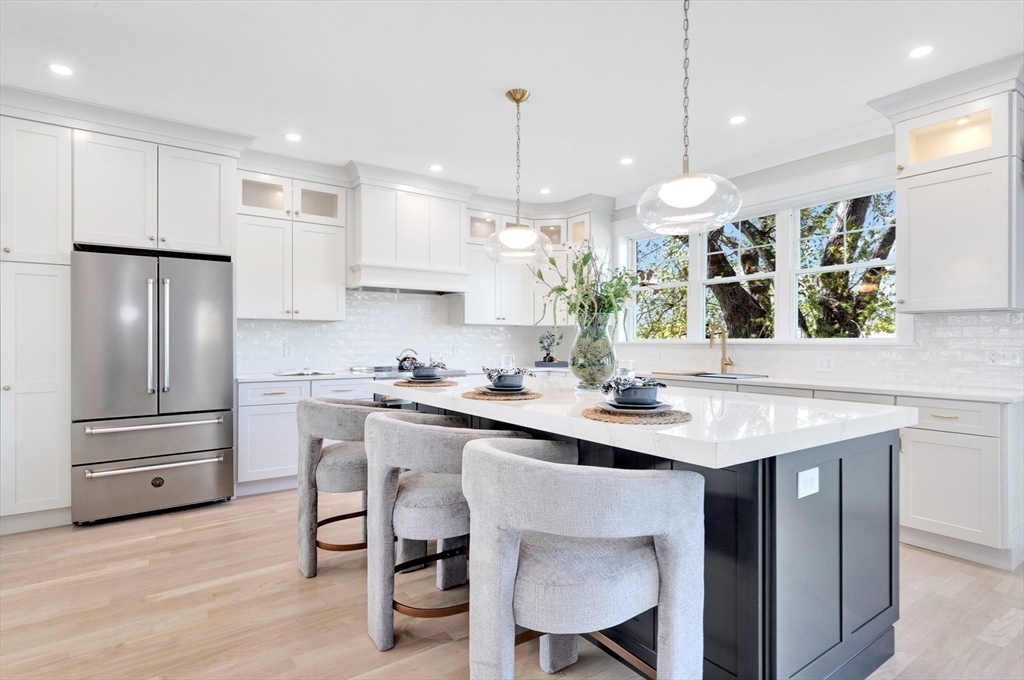 354 Ridge Street Arlington, MA 02474 - Photo 7 of 42 a kitchen with stainless steel appliances granite countertop a sink a stove a refrigerator and island with wooden floor