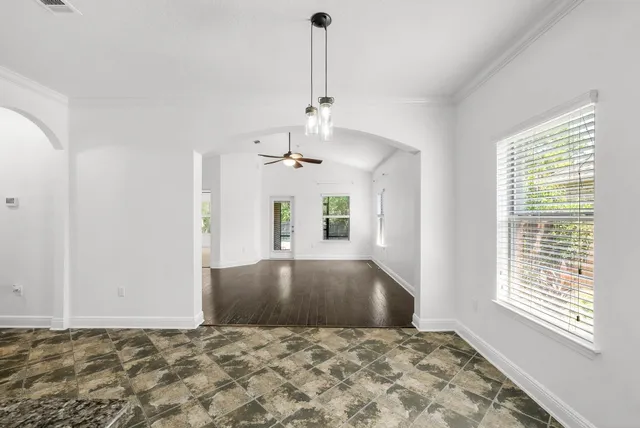 a view of empty room with window and ceiling fan