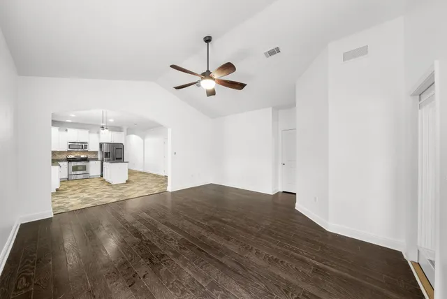 a view of kitchen and hall with wooden floor