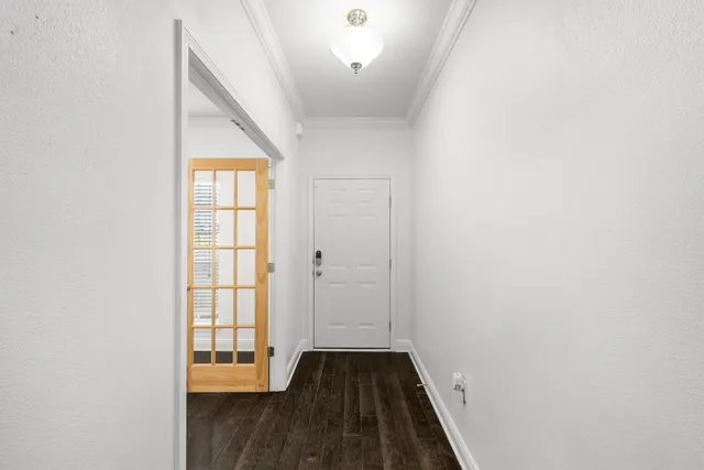 a view of a hallway with wooden floor and a window