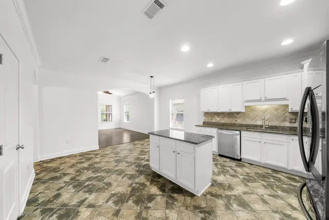 a kitchen with stainless steel appliances granite countertop a sink and cabinets