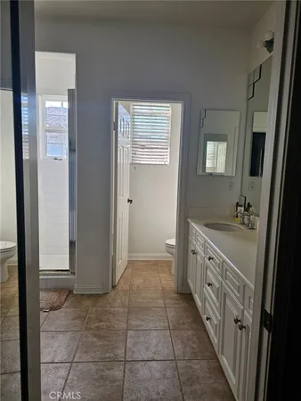 a bathroom with a double vanity sink a toilet and a mirror