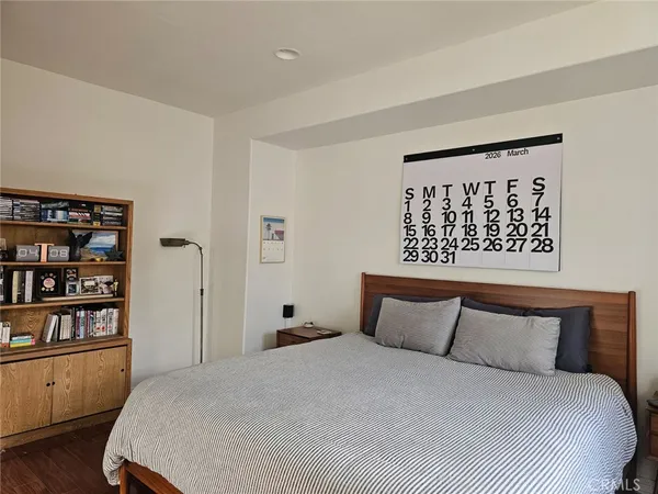 a bedroom with a large bed and a book shelf