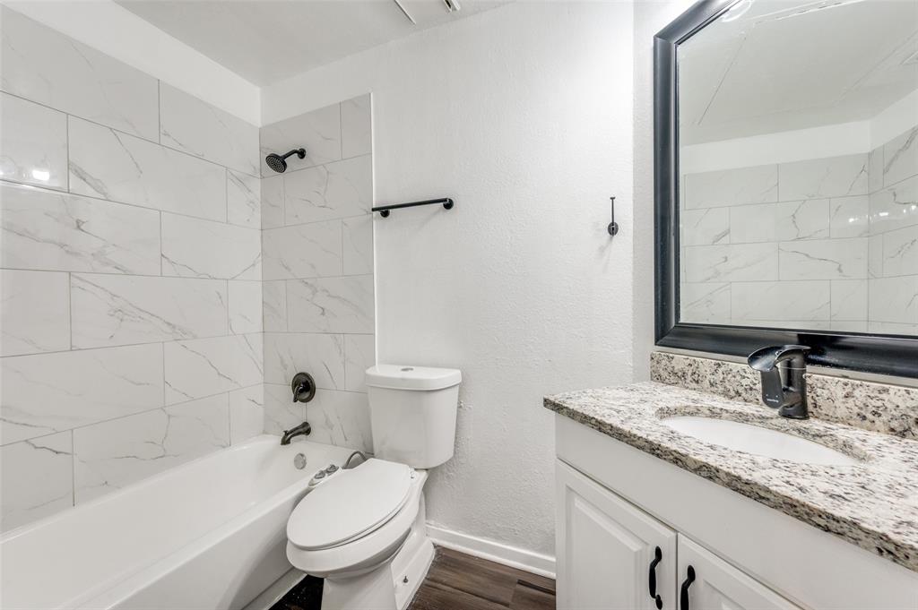 5550 Spring Valley Road, Unit E22 Dallas, TX 75254 - Photo 11 of 14 a bathroom with a granite countertop sink a toilet and a bathtub
