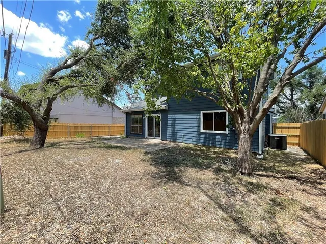 a tree in front of a white house