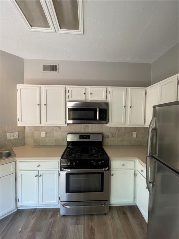 2114 Zephyr Lane Round Rock, TX 78664 - Photo 10 of 27 a kitchen with granite countertop a refrigerator stove and white cabinets