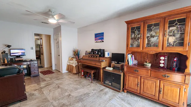 a workspace with kitchen island granite countertop a stove top oven a sink dishwasher and wooden cabinets
