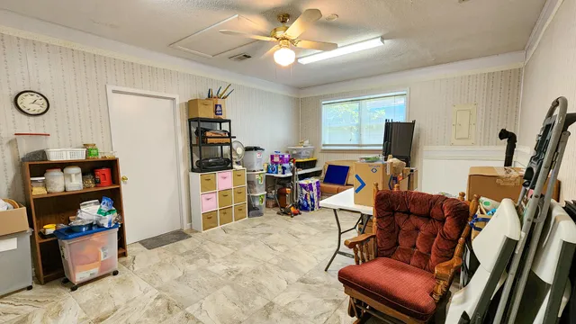 a living room with furniture a flat screen tv and a refrigerator