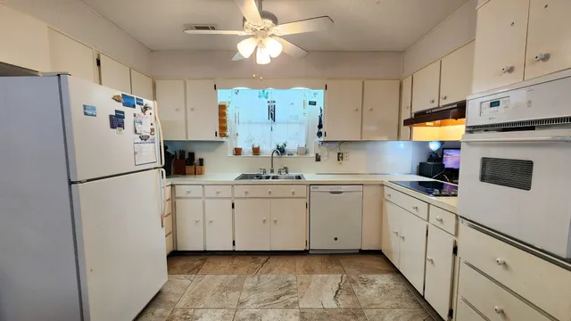 a kitchen with appliances a refrigerator and a sink