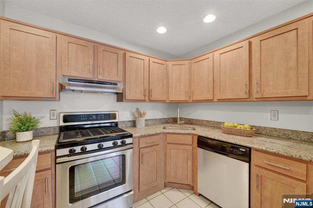 560 Holly Court Mahwah, NJ 07430 - Photo 19 of 33 a kitchen with granite countertop white cabinets and white appliances