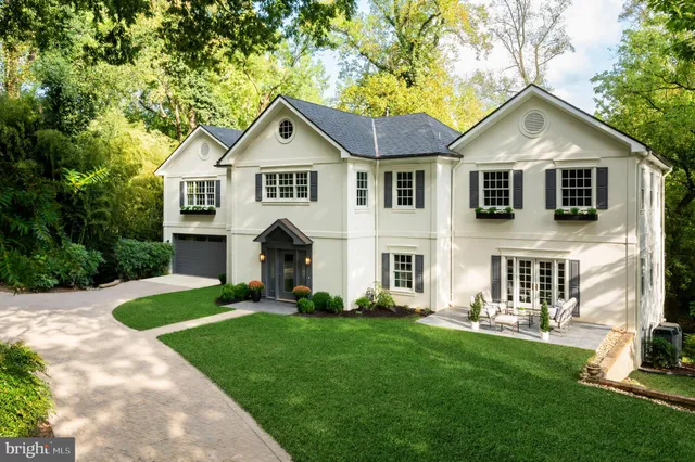 a front view of a house with a yard and trees