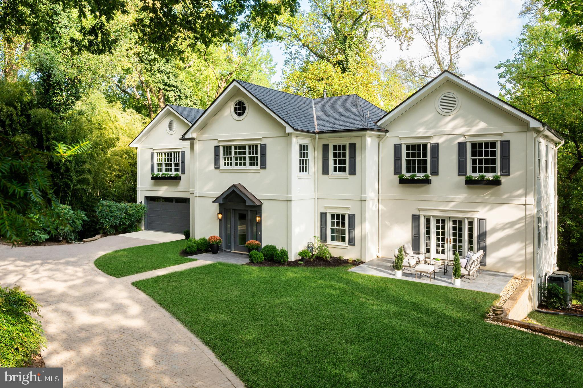 a front view of a house with a yard and trees
