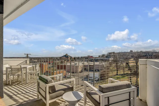 a view of a terrace with dining table & chairs
